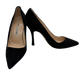 Black high-heeled shoes with brand label on a white background