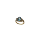 Gold ring with a blue gemstone on a white background