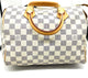 Checkered handbag with gold handle and accents on a white background