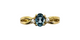 Gold ring with a blue gemstone and diamonds on a white background