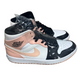 Pair of high-top sneakers with a black, white, and pink design on a concrete floor.