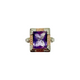 Ring with a purple gemstone and gold and silver accents on a white background