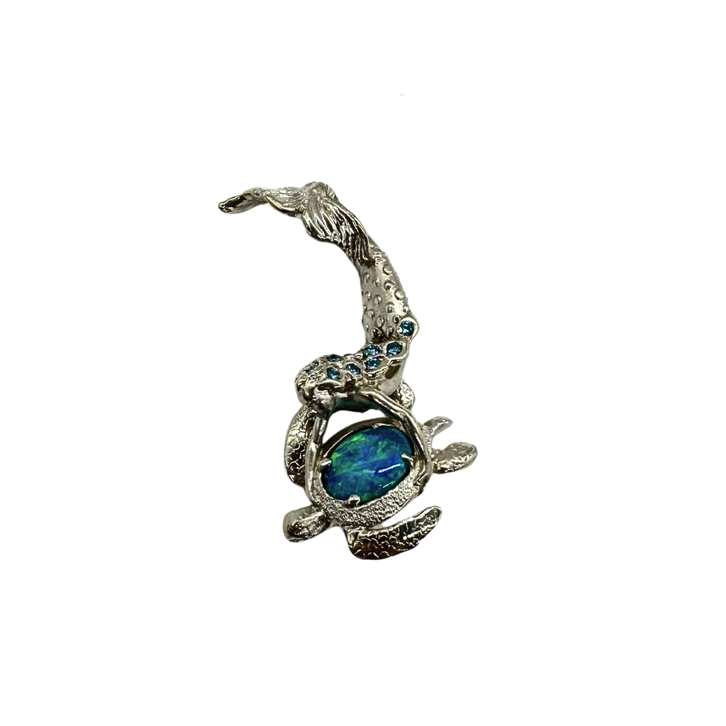 Silver turtle pendant with blue gemstone on a white background