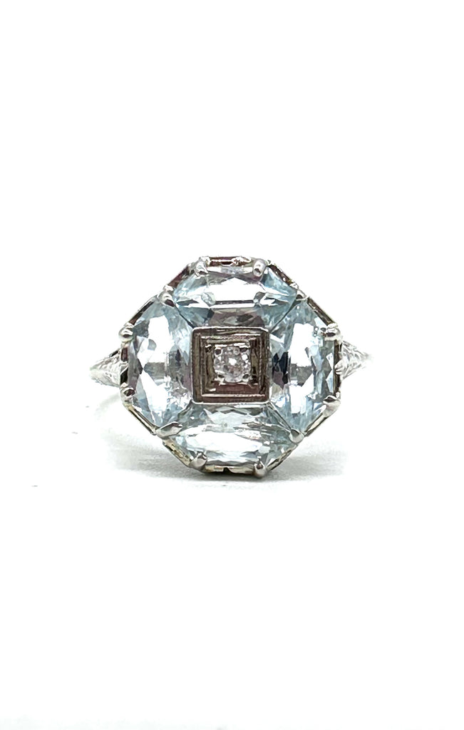 Diamond ring with a large central diamond and smaller diamonds on the band against a white background