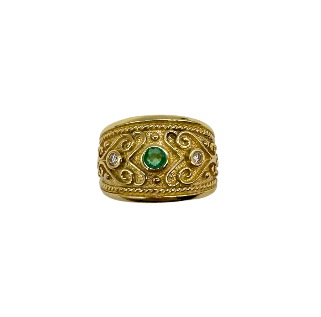 Gold ring with emerald and diamonds on a white background