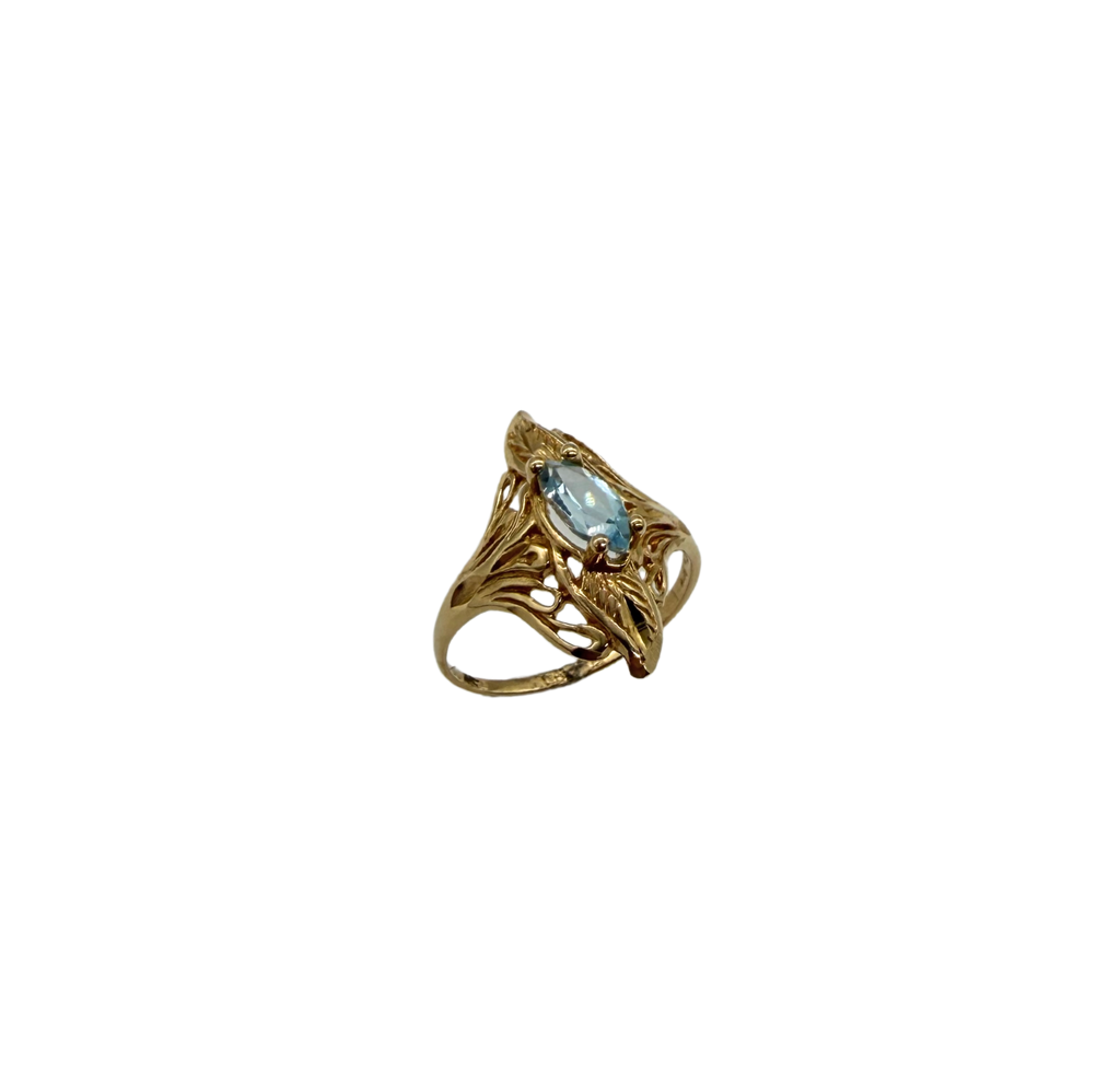 Gold ring with a blue gemstone on a white background