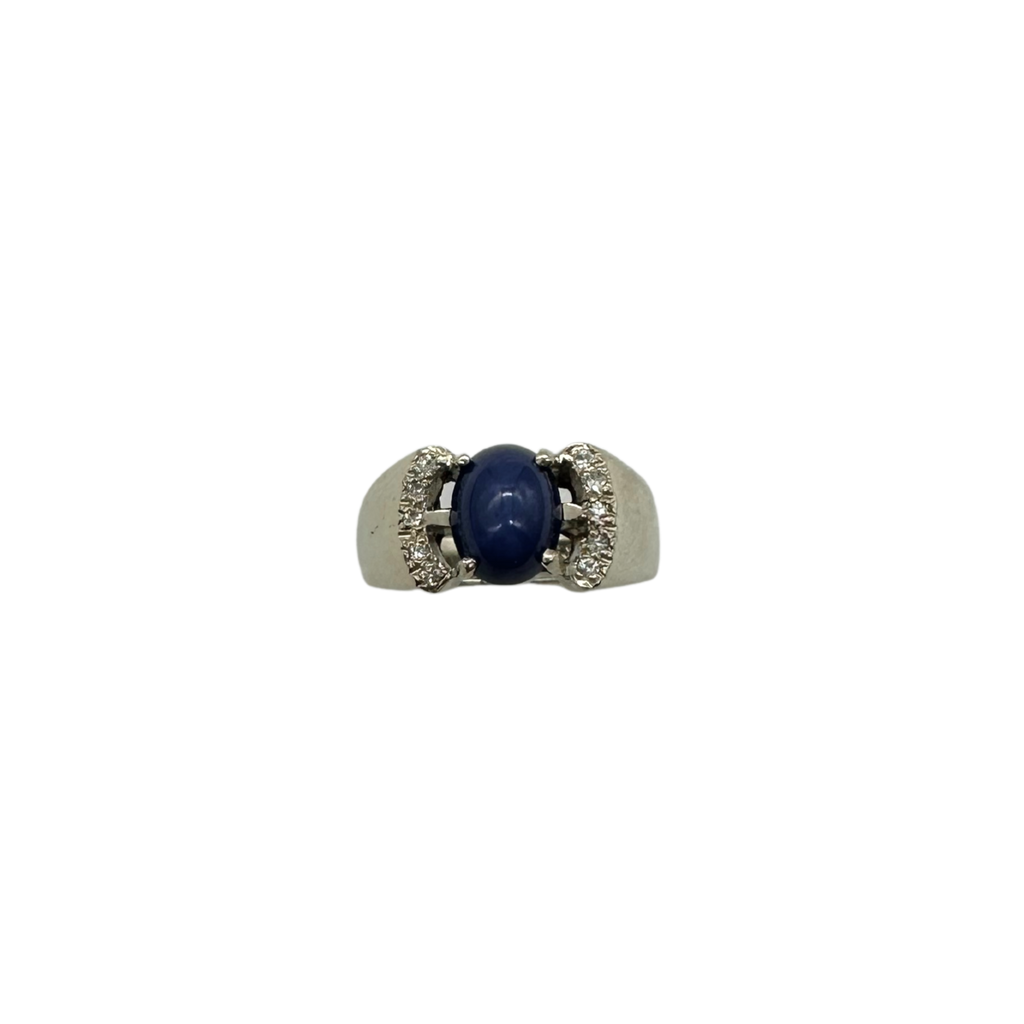 Ring with a blue gemstone and silver band on a white background