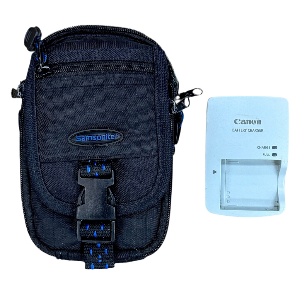 Canon PowerShot SD1300 IS 12.1 MP Digital Camera w/ Case Black Samsonite camera bag with a Canon battery charger on a white background