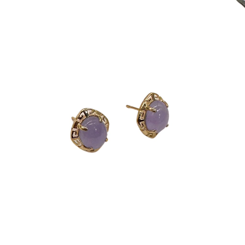Pair of gold earrings with purple stones on a white background