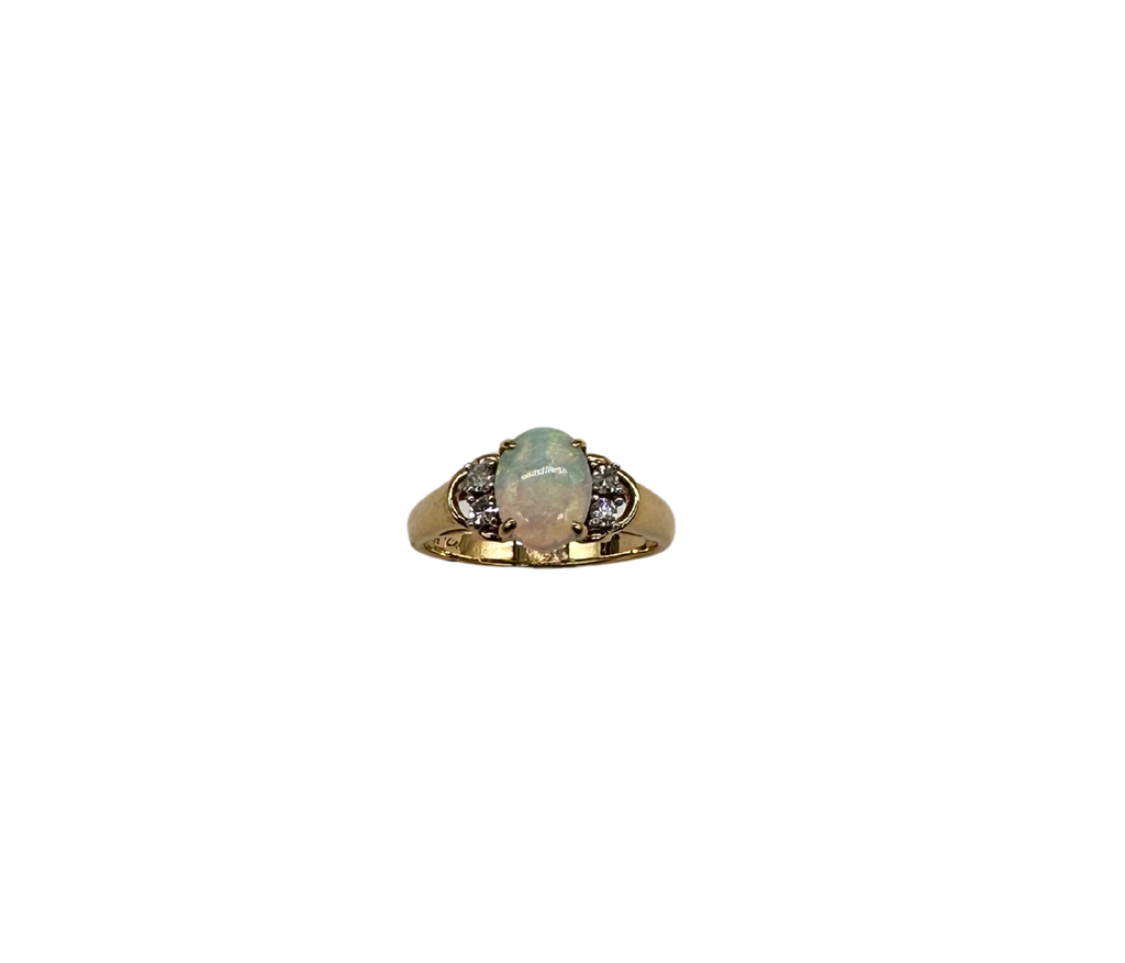 Gold ring with a central gemstone and smaller stones on a white background
