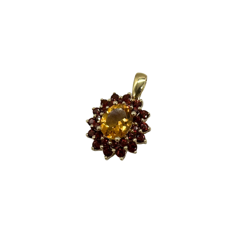 Gold pendant with a central yellow gemstone and smaller red gemstones on a white background