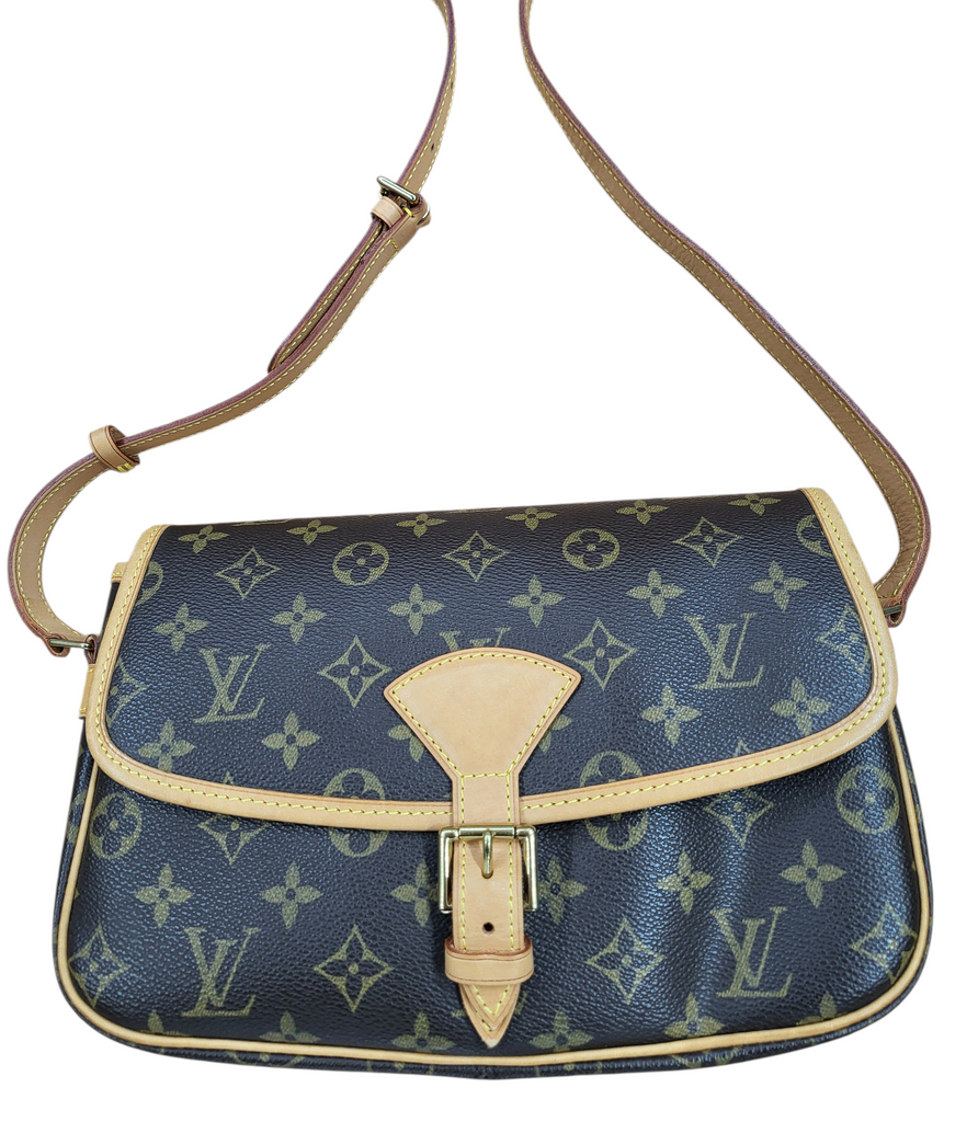 Blue handbag with beige accents and monogram pattern on a white background