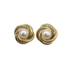 Pair of gold earrings with pearl centers on a white background