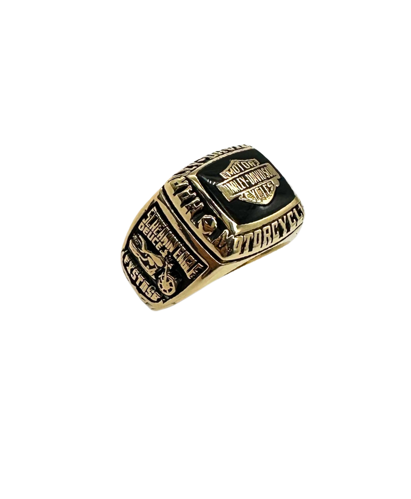 Gold and black ring with engraved text on a white background