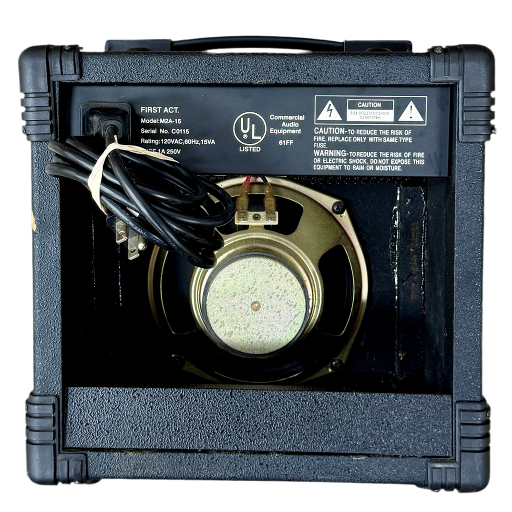 First Act Mark II M2A-15 Guitar Combo Amplifier Black electronic device with a circular component and visible branding on a white background