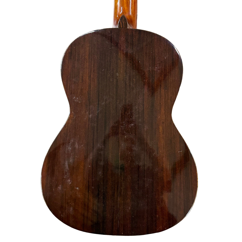 Vintage KASUGA KC-330 Classical Guitar Back of a wooden acoustic guitar on a tiled floor