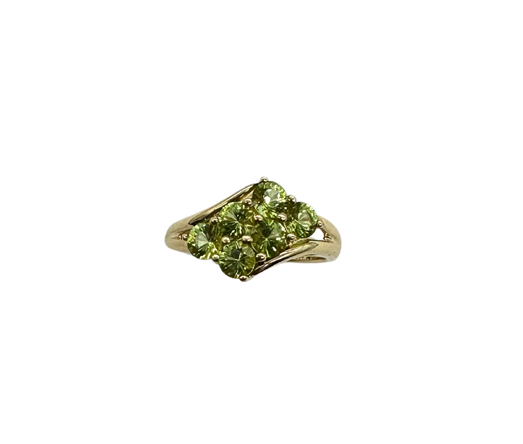 Gold ring with green gemstone on a white background