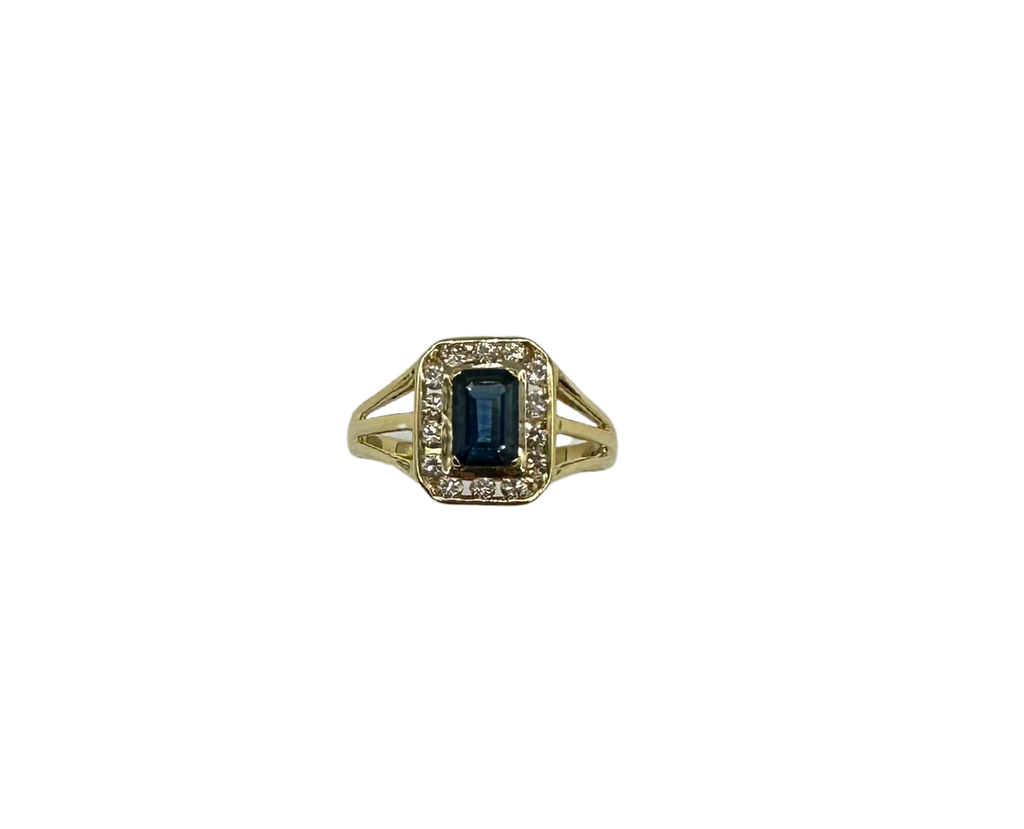 Gold ring with a blue gemstone and diamonds on a white background