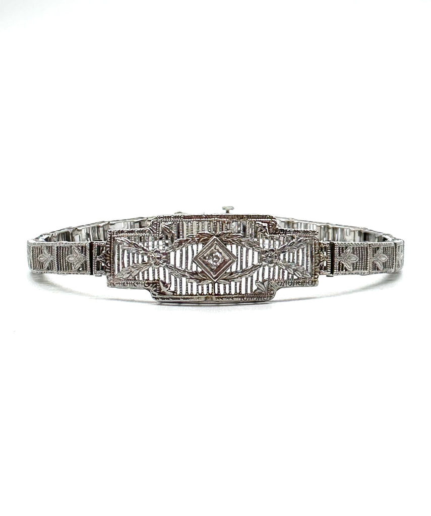 Silver bracelet with intricate design on a white background