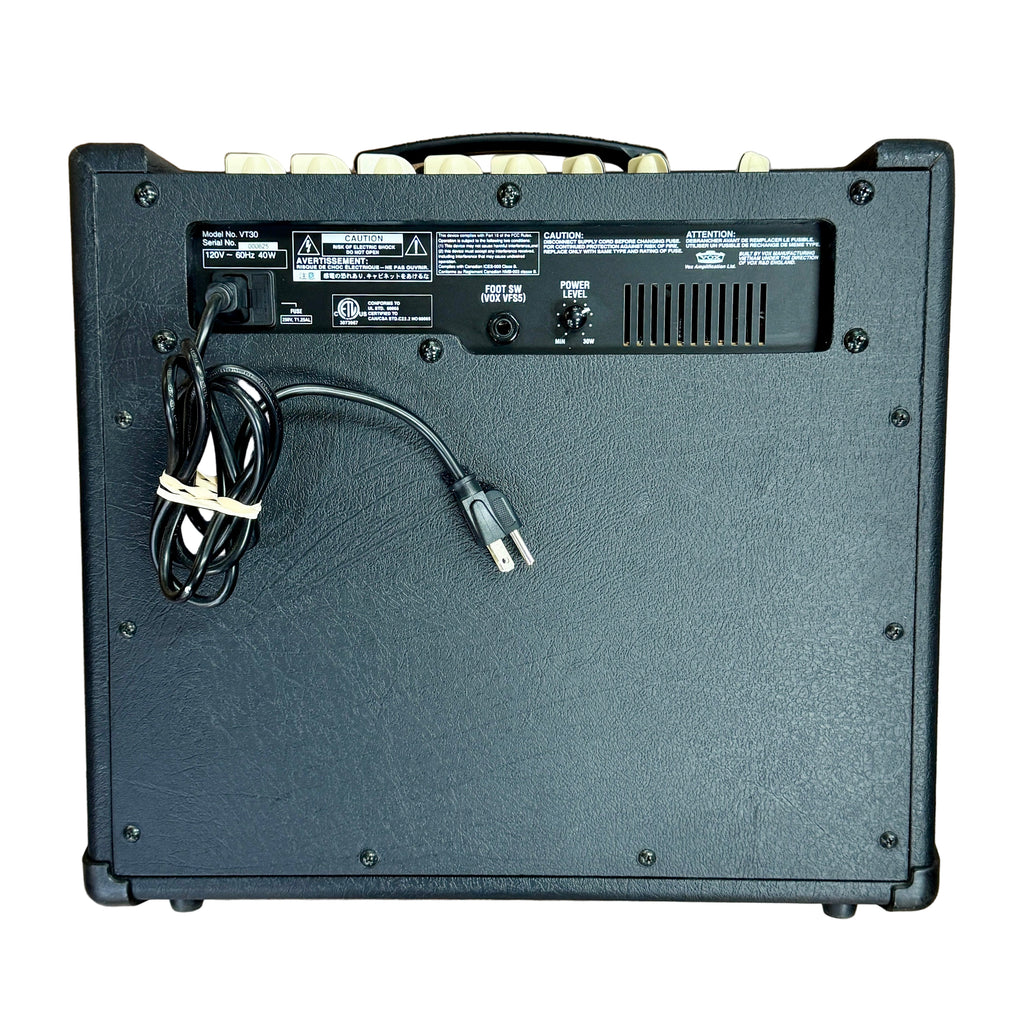 VOX Valvetronix VT30 Guitar Combo Amplifier Back view of a guitar amplifier with cables on a wooden surface