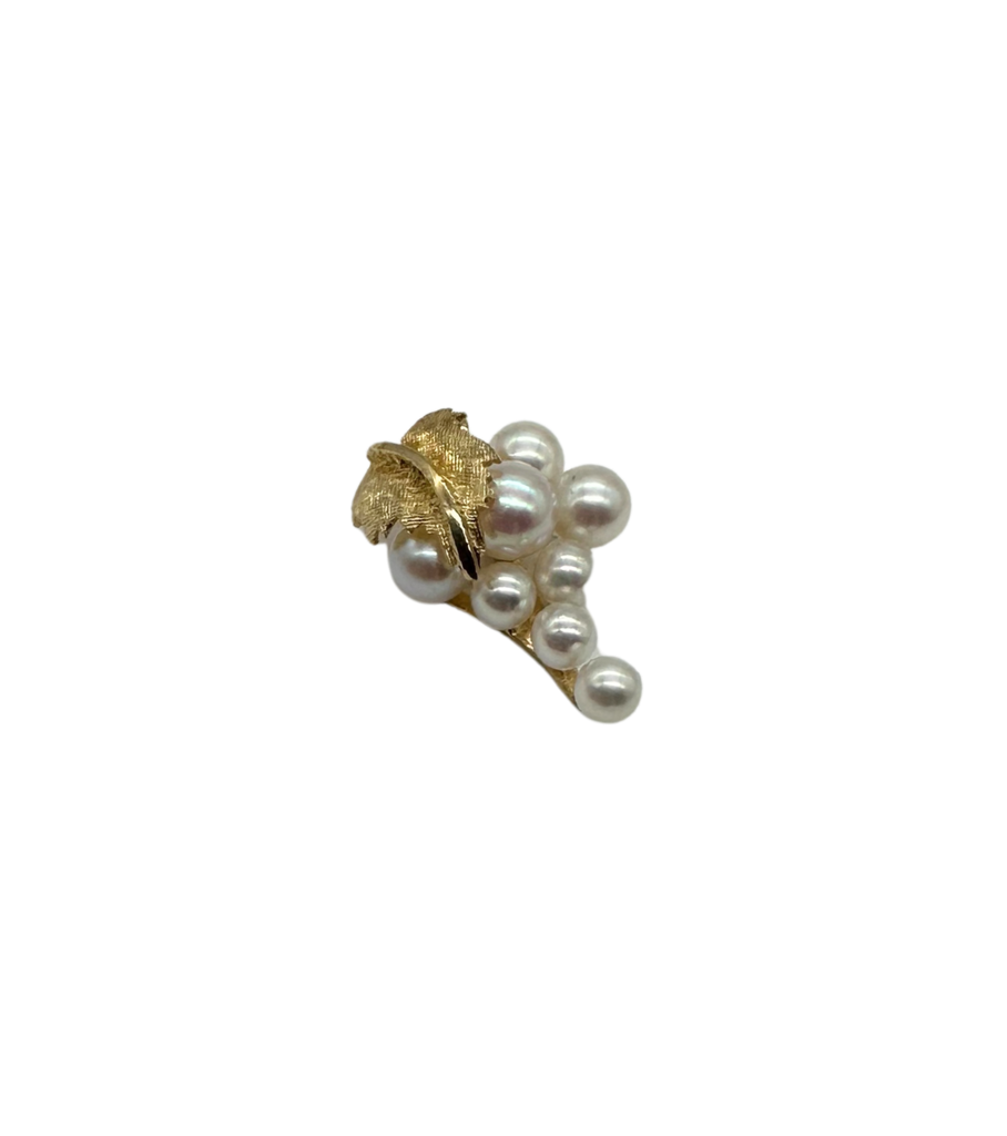 Gold and pearl brooch on a white background