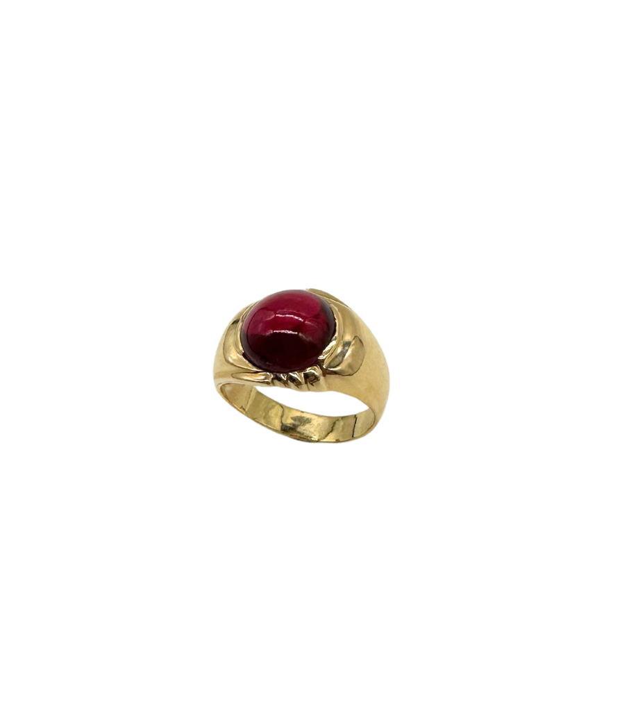 Gold ring with a red gemstone on a white background