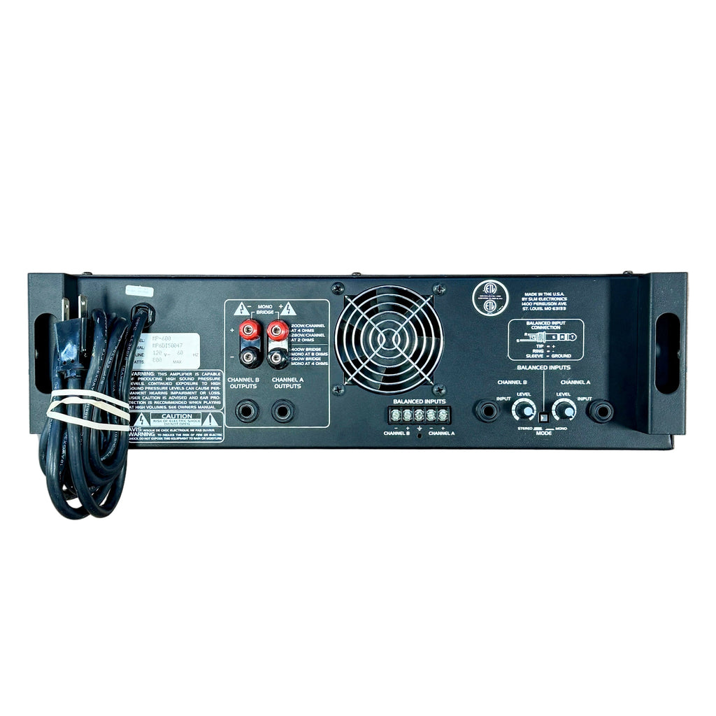 Audio Centron EQUINOX MP-600 Power Amplifier Black electronic device with cables on a wooden floor, with shoes at the bottom.