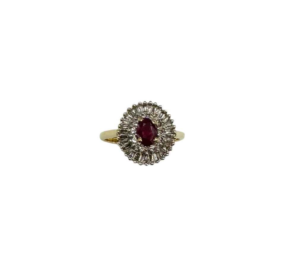 Gold ring with a central red gemstone and diamond-like stones on a white background