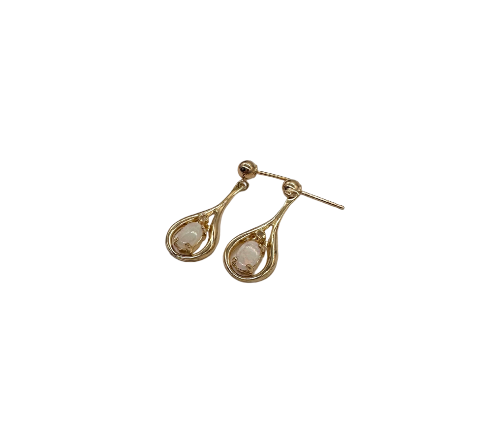 Gold teardrop earrings with clear gemstones on a white background