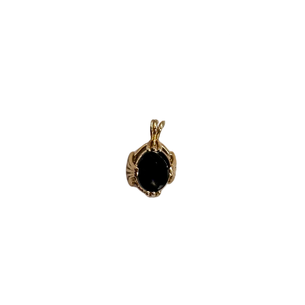 Gold pendant with a black stone on a white background