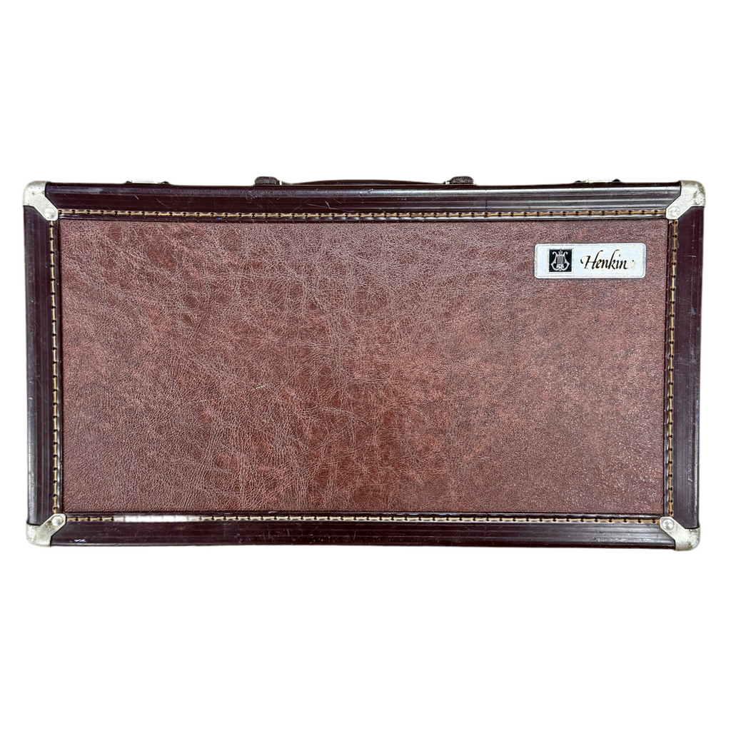 Henkin Bb Clarinet w/ Hard Case Brown guitar case with silver trim and a brand logo on a white background
