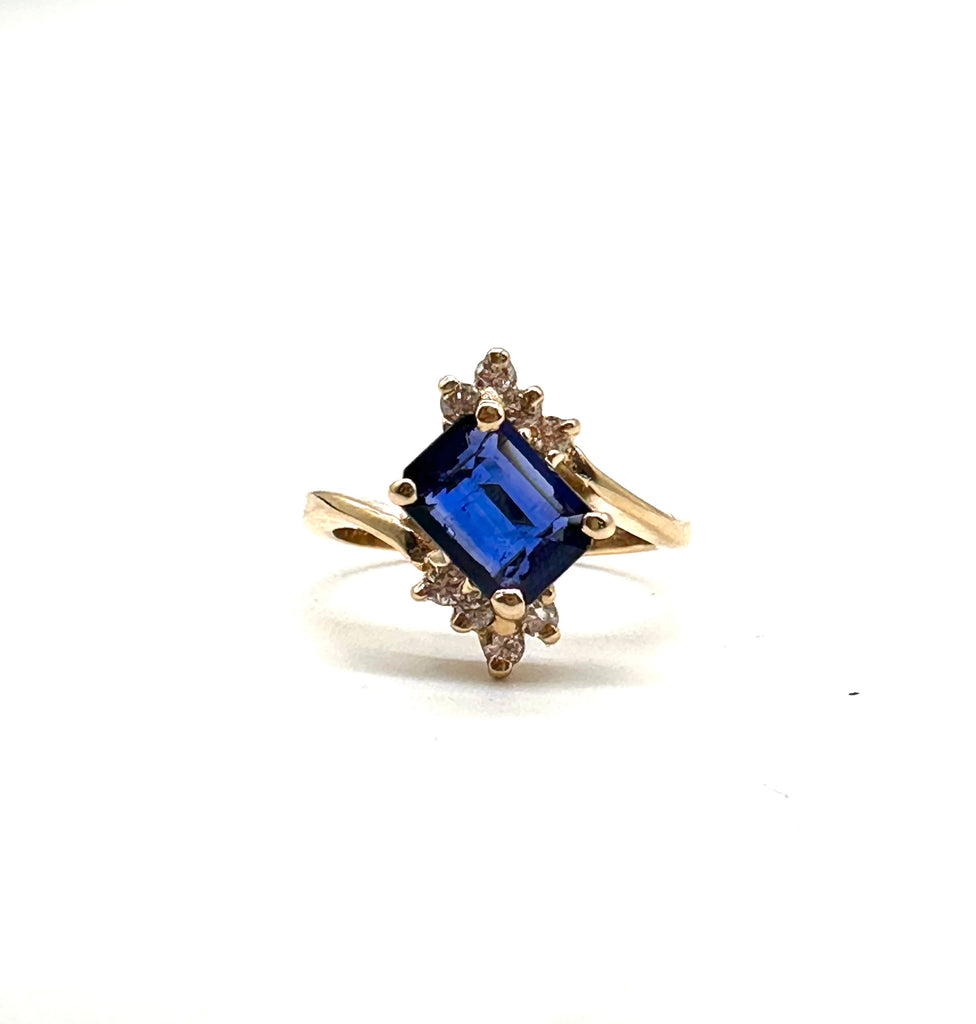 Gold ring with a blue gemstone on a white background
