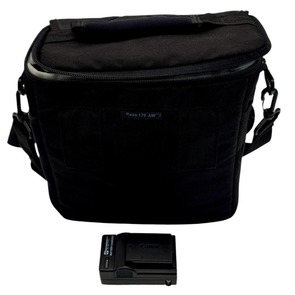 Canon EOS Rebel T3 12.2 MP CMOS Digital SLR Camera w/ Canon Zoom Lens EF-S 18-55mm f/3.5-5.6 IS II & Canon Zoom Lens EF 75-300mm f/4-5.6 III Lenses Black camera bag with a Canon battery and charger on a white background