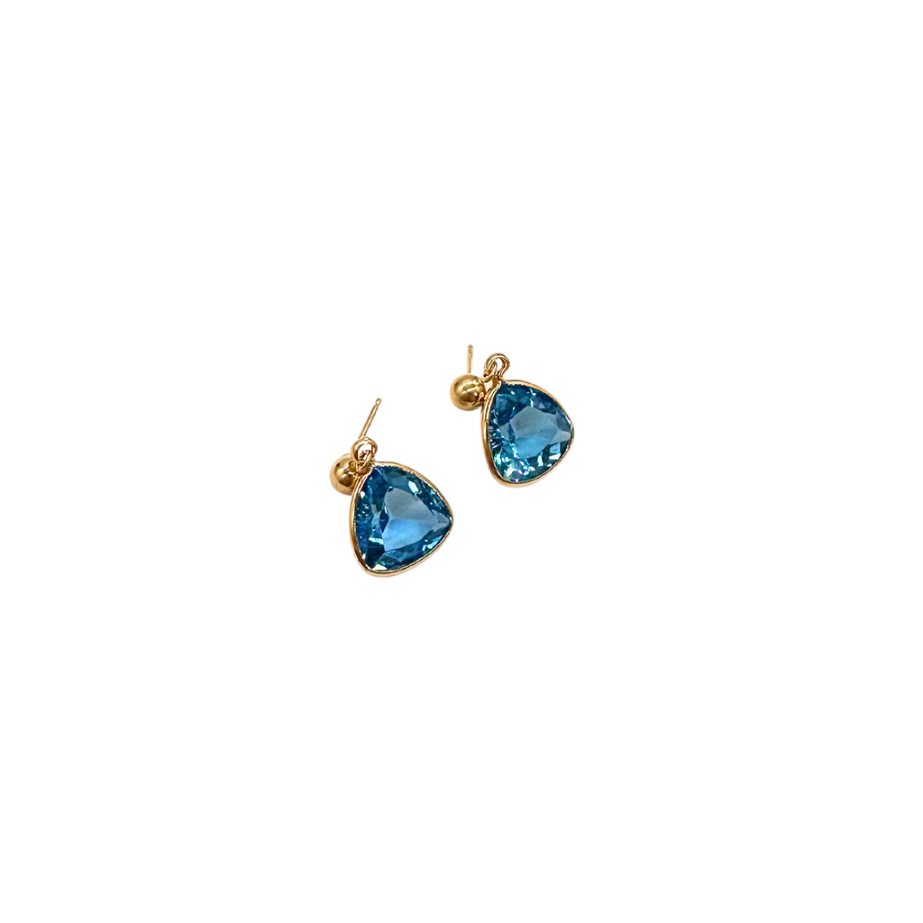 Gold earrings with blue gemstones on a white background