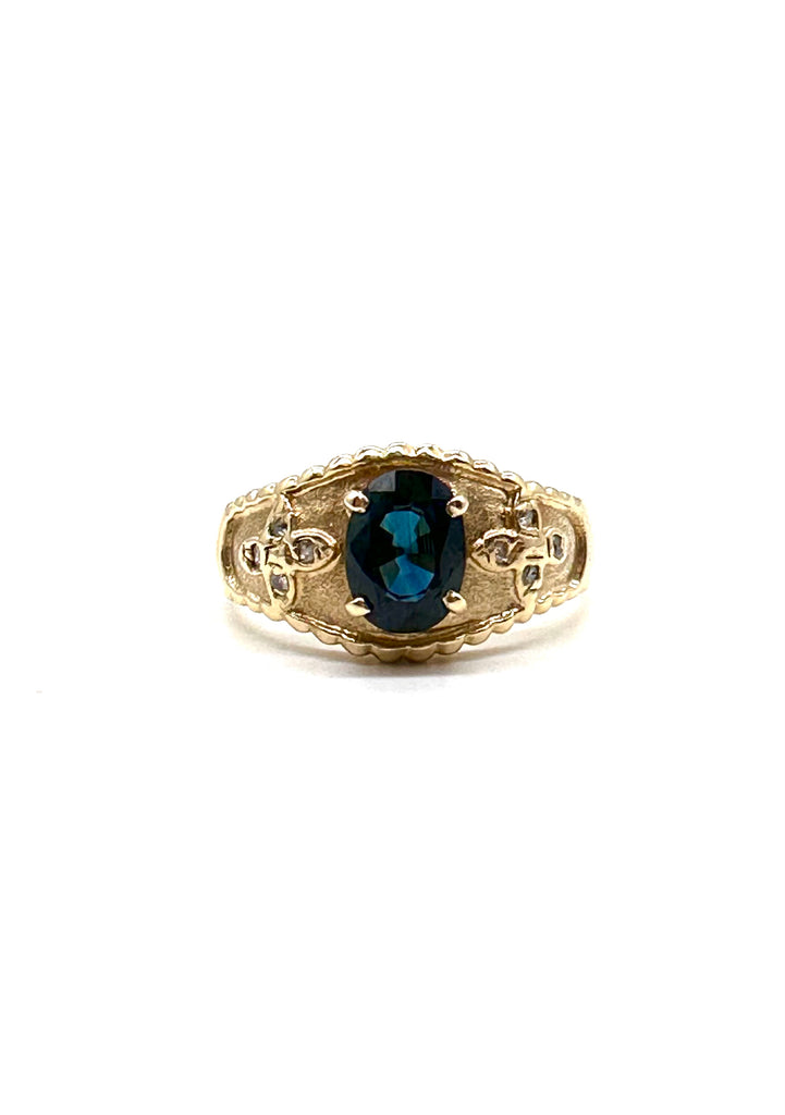 Gold ring with a blue gemstone on a white background