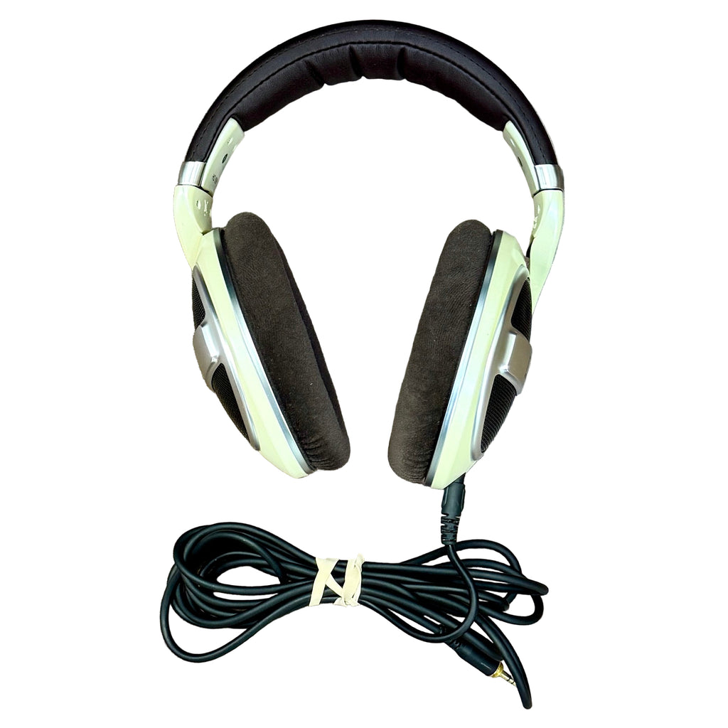 Sennheiser HD 599 Open-Back Over-Ear Audiophile Headphones - Ivory Headphones with a coiled cable on a wooden surface