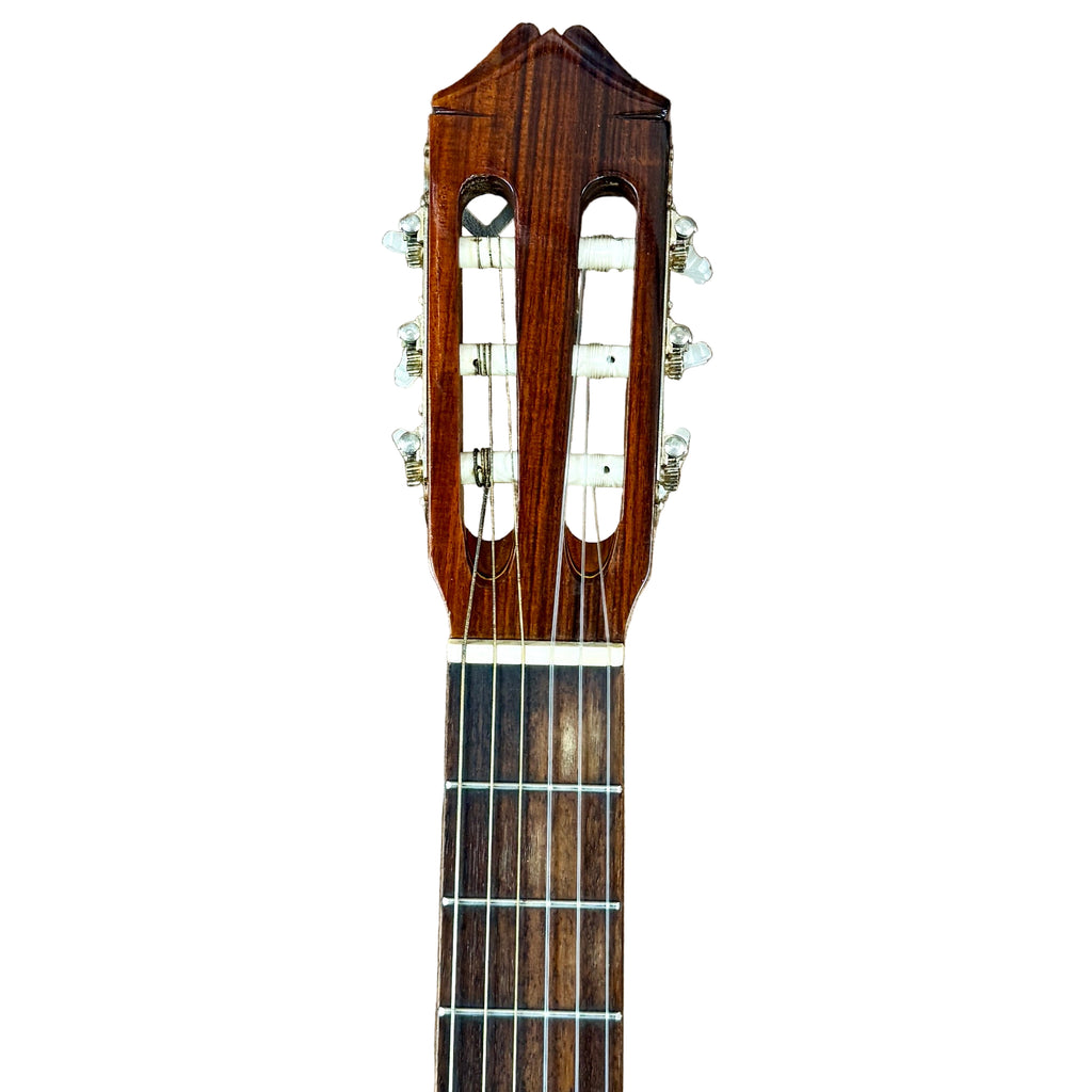 Vintage KASUGA KC-330 Classical Guitar Close-up of a guitar headstock with tuning pegs on a wooden surface
