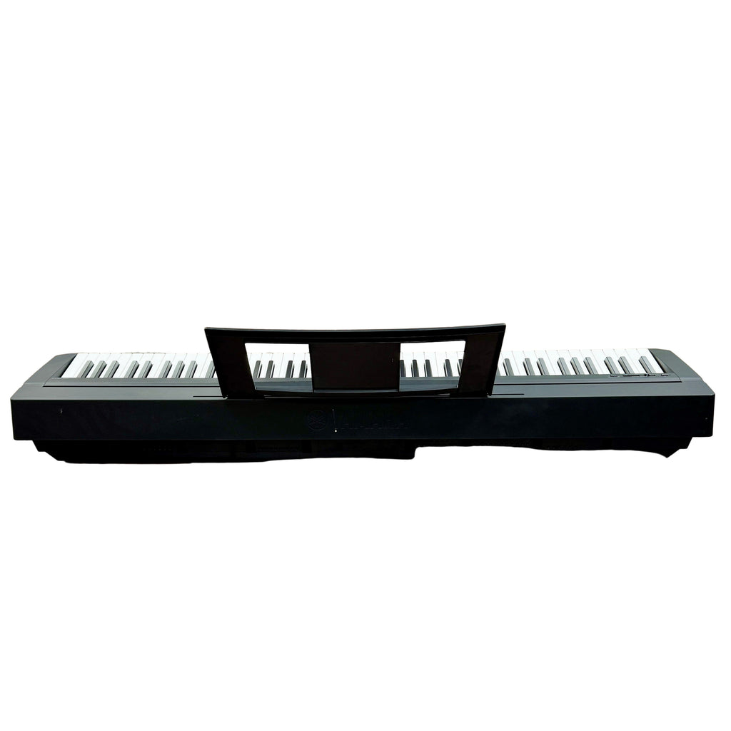 Yamaha P-45 88-Key Digital Piano w/ Speakers Black digital piano on a wooden floor with a store interior in the background