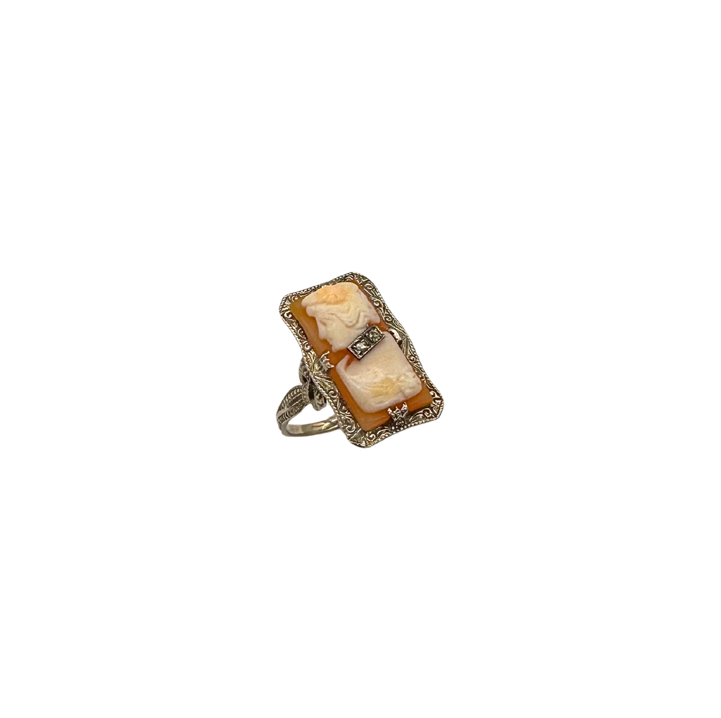 Ring with a large beige stone and smaller diamond on a white background