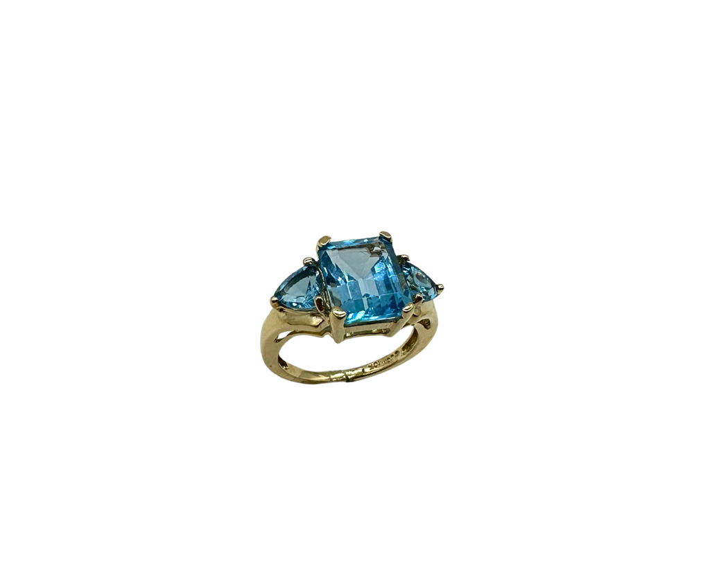 Gold ring with a blue gemstone on a white background