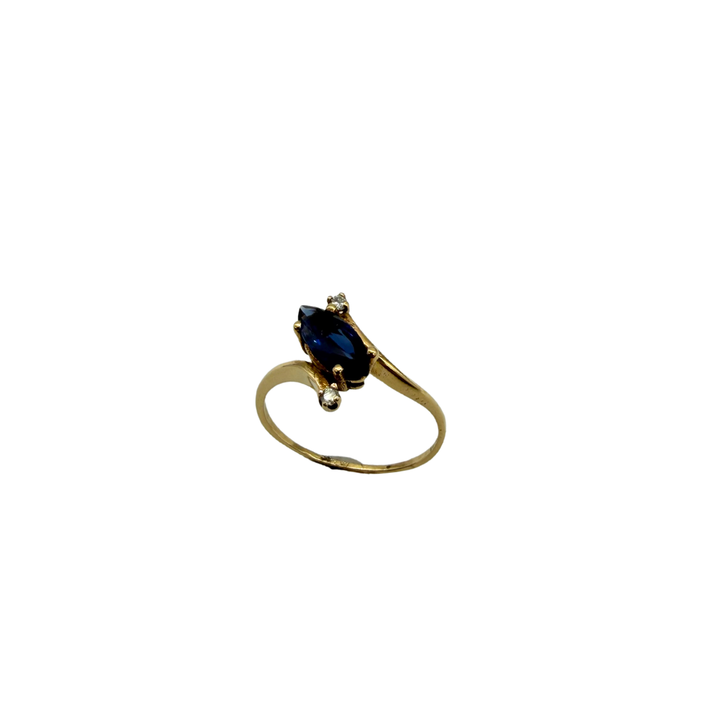 Gold ring with a blue gemstone on a white background