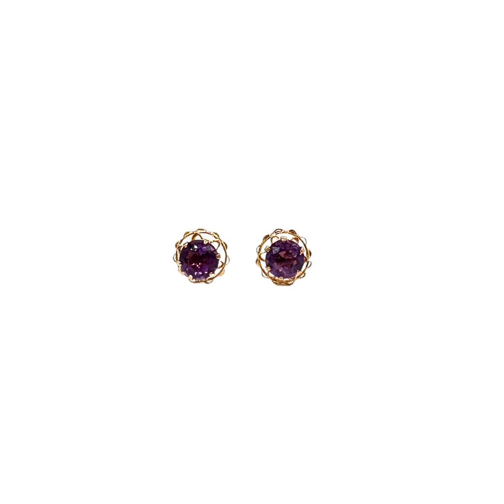 Pair of gold earrings with purple gemstones on a white background