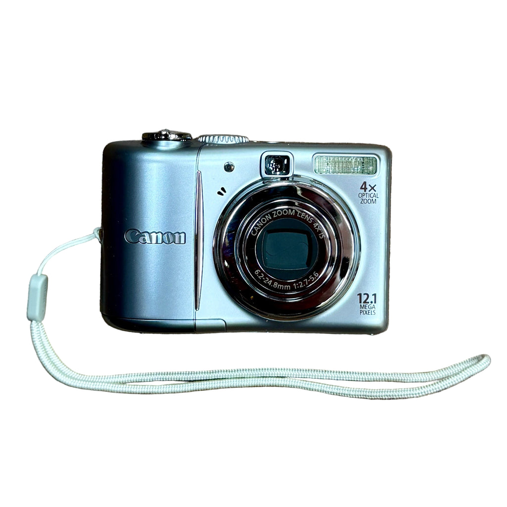 Canon PowerShot A1100 IS 12.1 MP Digital Camera w/ Case - Silver Canon digital camera with strap on a white background