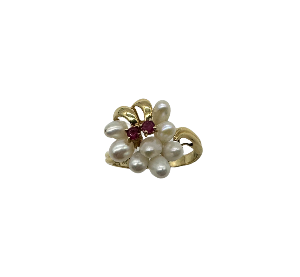 Gold ring with pearls and a red gemstone on a white background