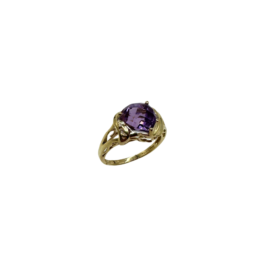 Gold ring with a purple gemstone on a white background
