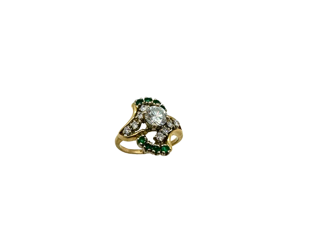 Gold ring with a central diamond and emeralds on a white background