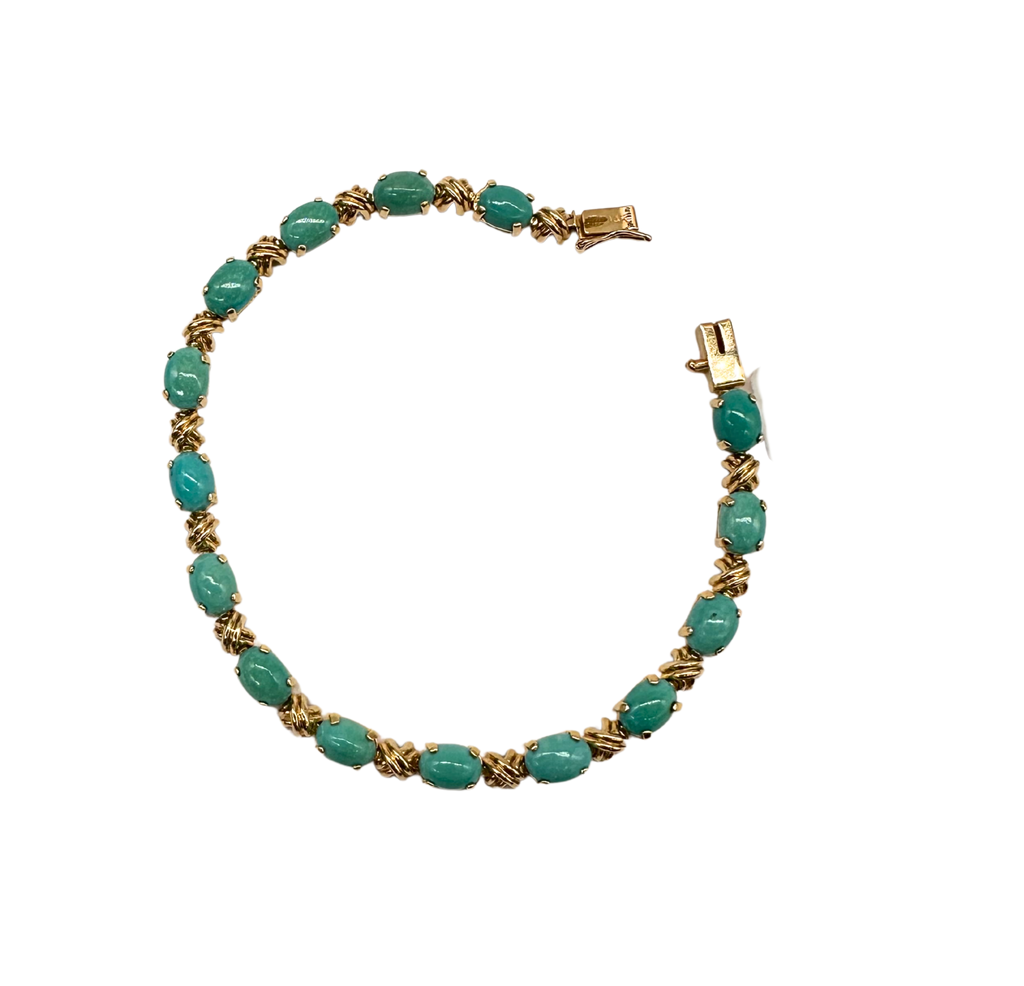 Turquoise beaded bracelet with gold accents on a white background
