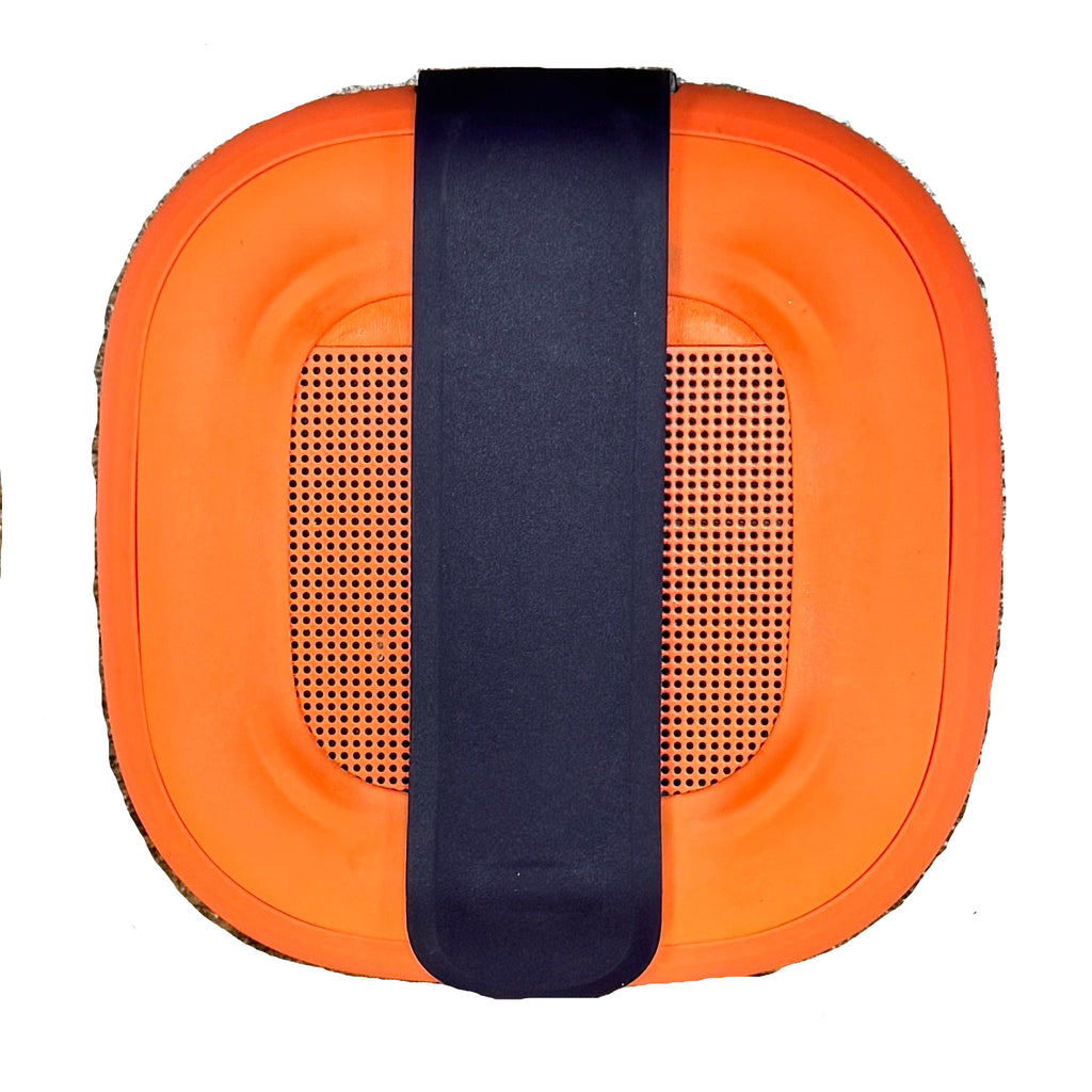 BOSE SoundLink Micro Portable Bluetooth Speaker - Orange cushion with a black strap on a textured surface