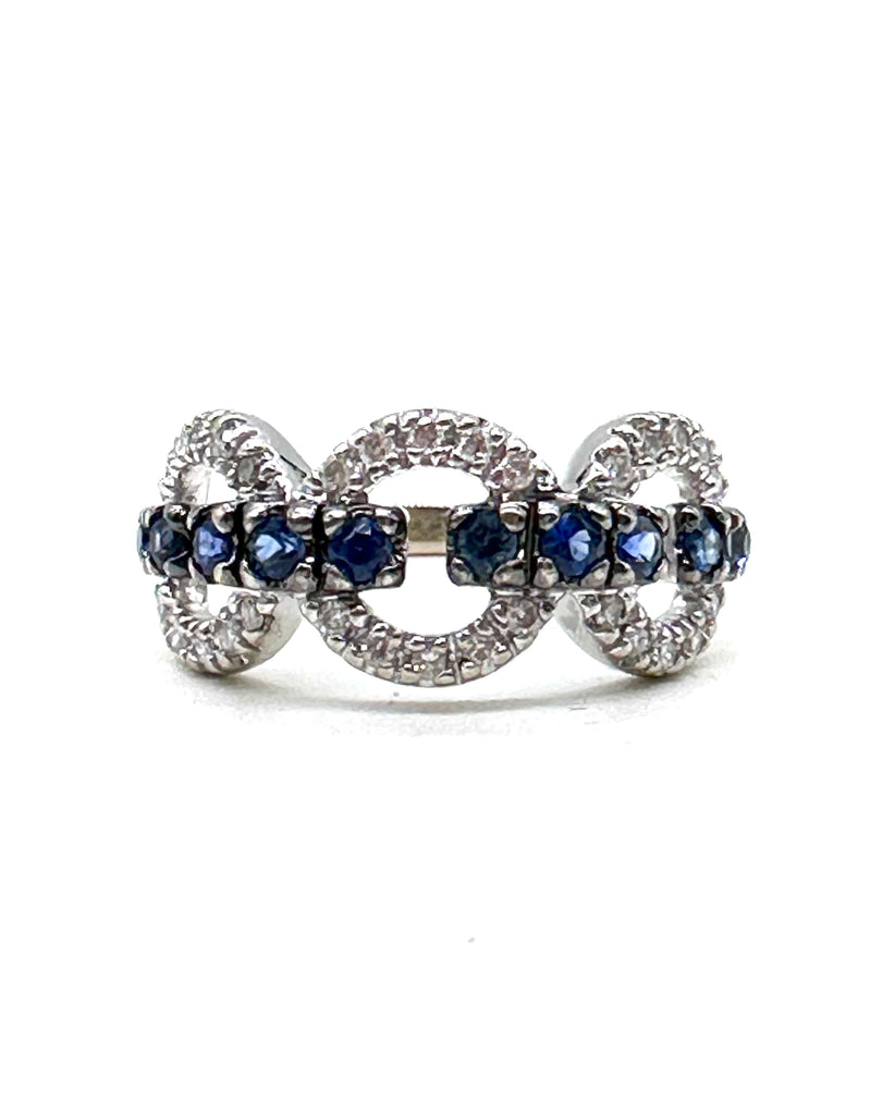 Ring with blue gemstones and diamond accents on a white background