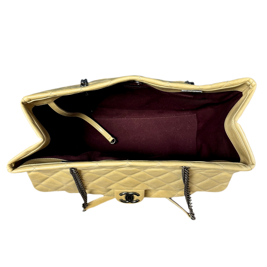 CHANEL Glazed Calfskin Leather Quilted Small Duo Color Tote Bag - Beige Gold quilted handbag with a visible Chanel logo on a white background